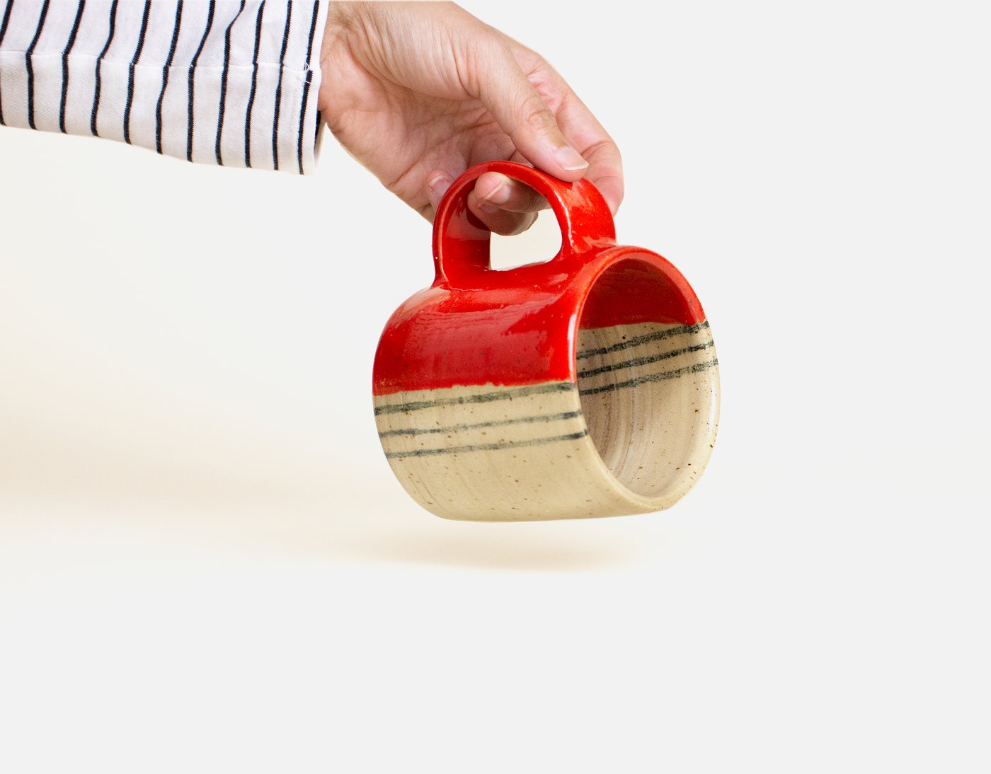 SF Ceramicist — red-striped mug held in hand
